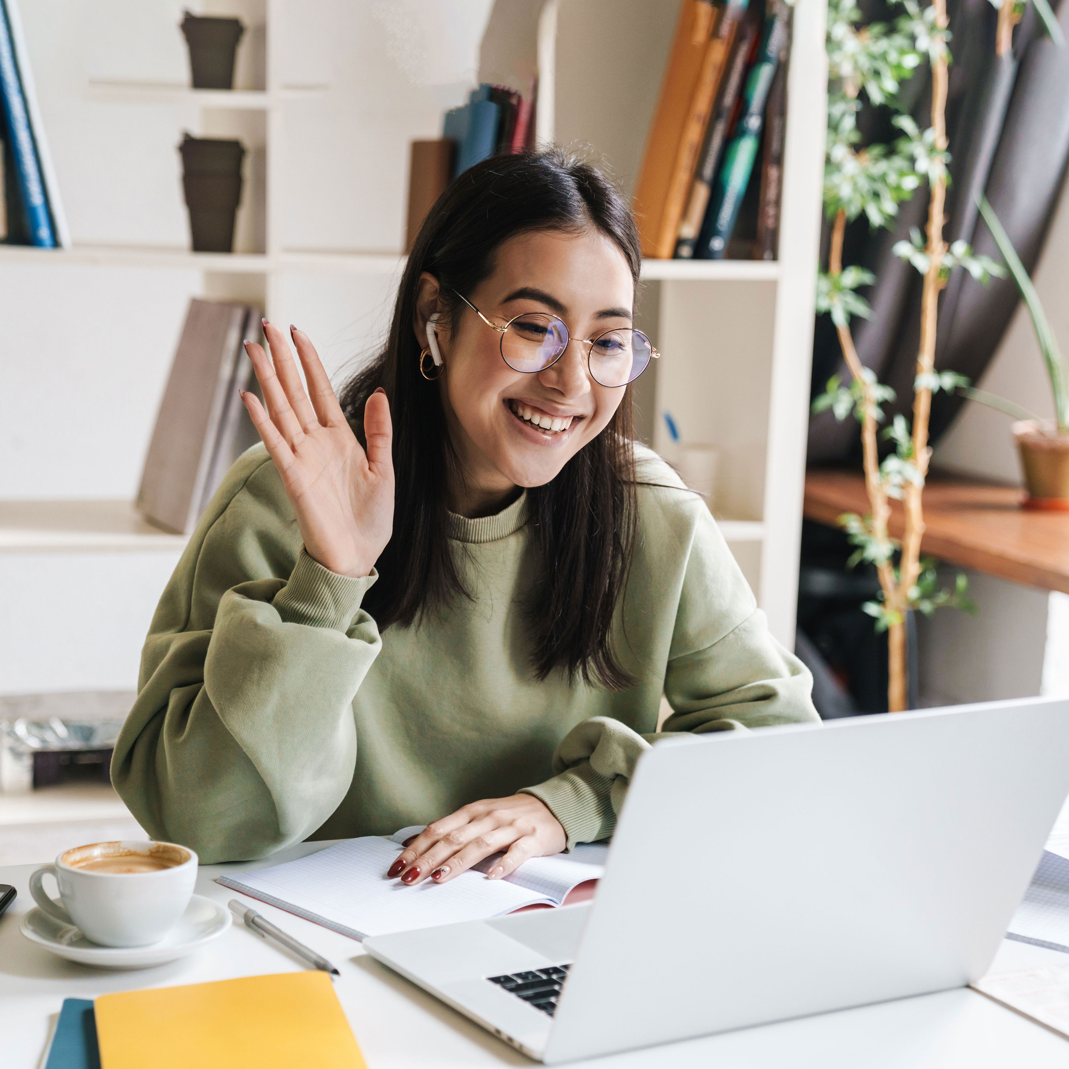 Health and social services student waving in front of laptop