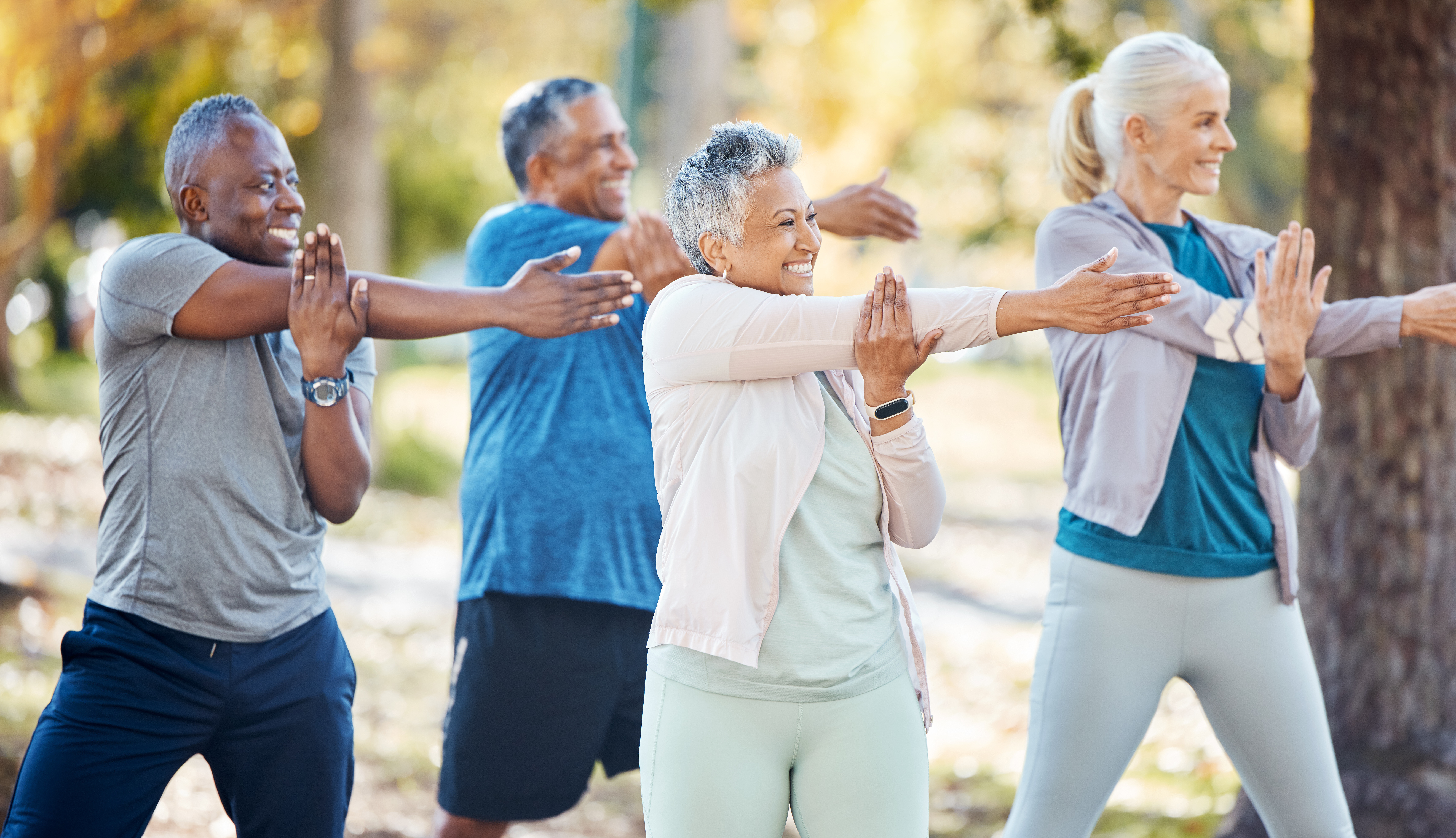 A group of older adults stretching outside.